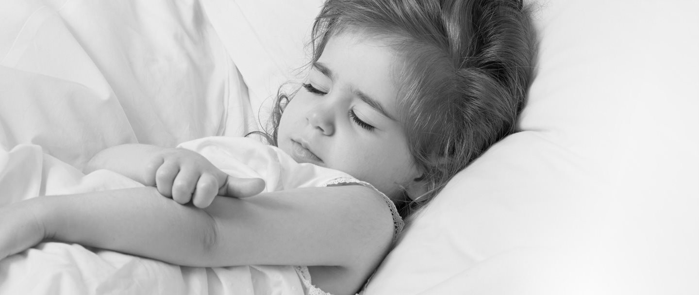 Niña pequeña rascándose el brazo.